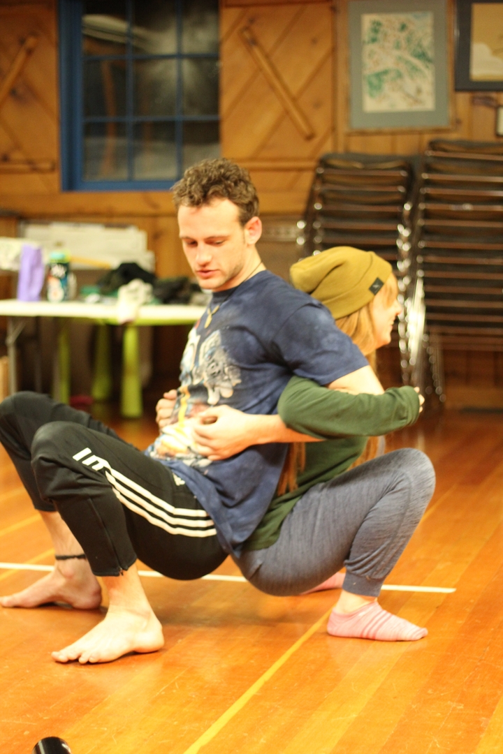 Deux personnes assises dos à dos à l'intérieur.