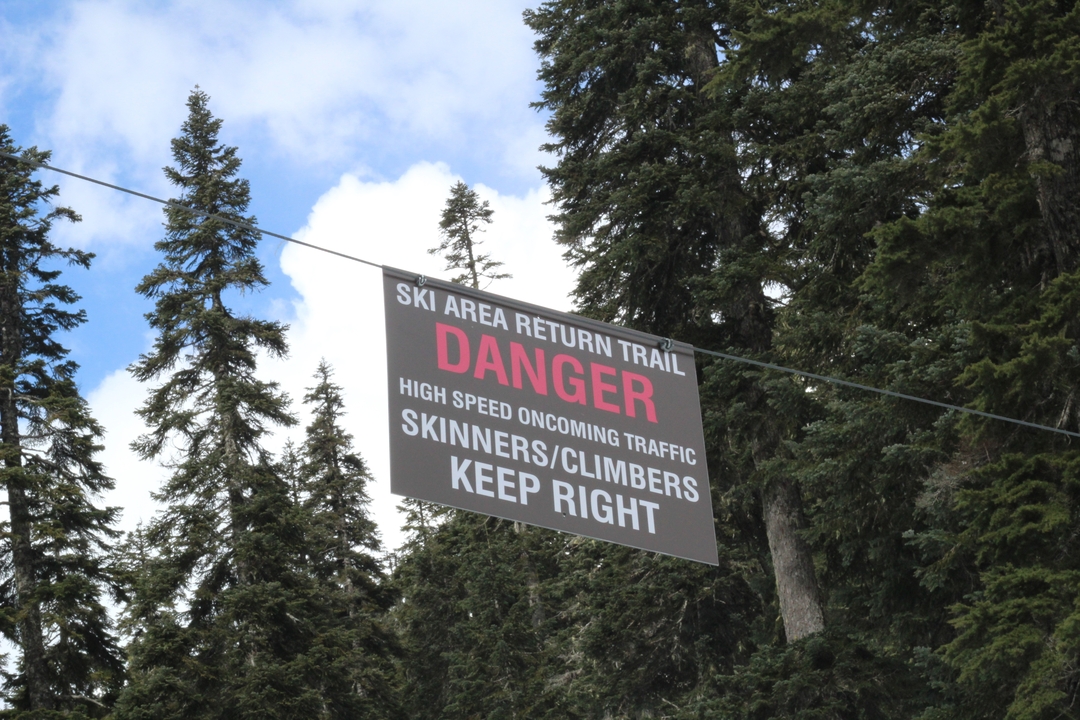 Panneau d'avertissement dans un domaine skiable enneigé.