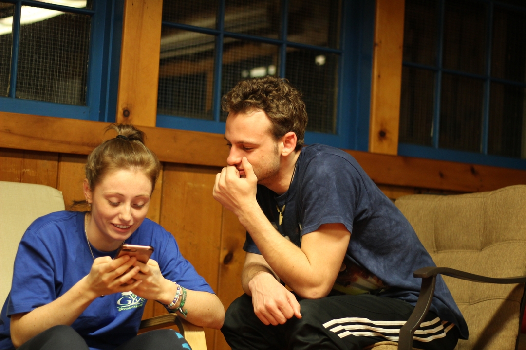 Deux personnes à l'intérieur, regardant un téléphone.