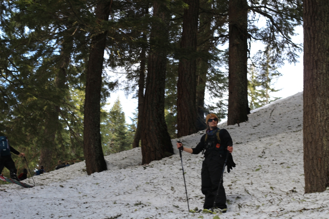 Personne posant sur la neige avec des arbres en arrière-plan.