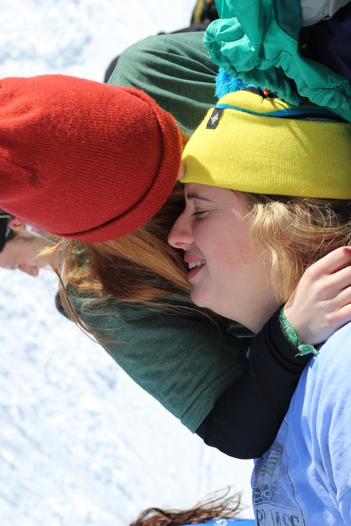 Deux personnes s'étreignent à l'extérieur en portant des bonnets.