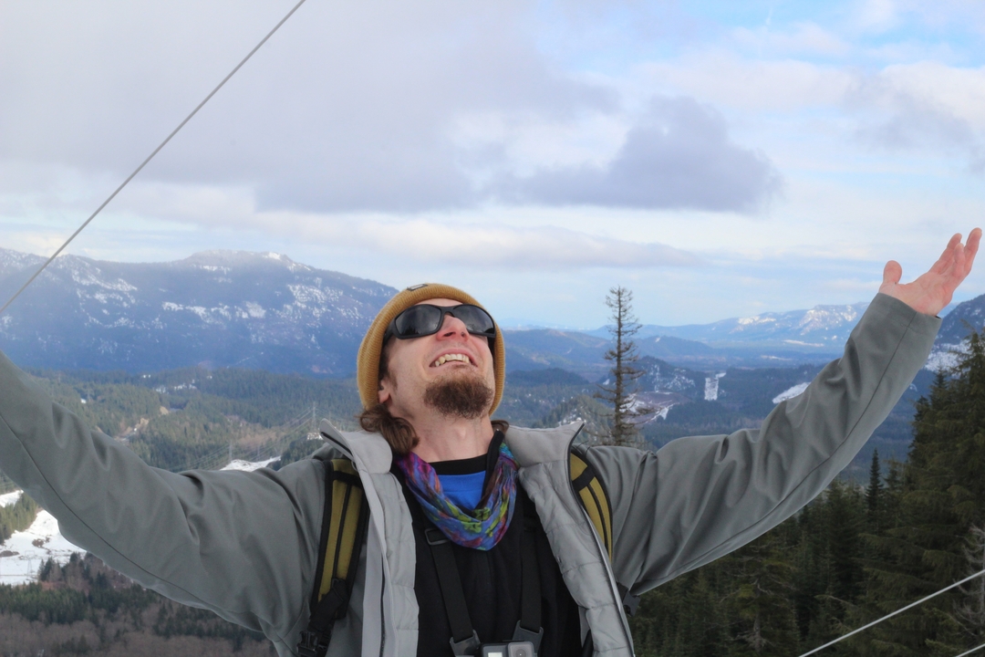 Personne faisant la fête, les bras levés, dans un paysage enneigé.