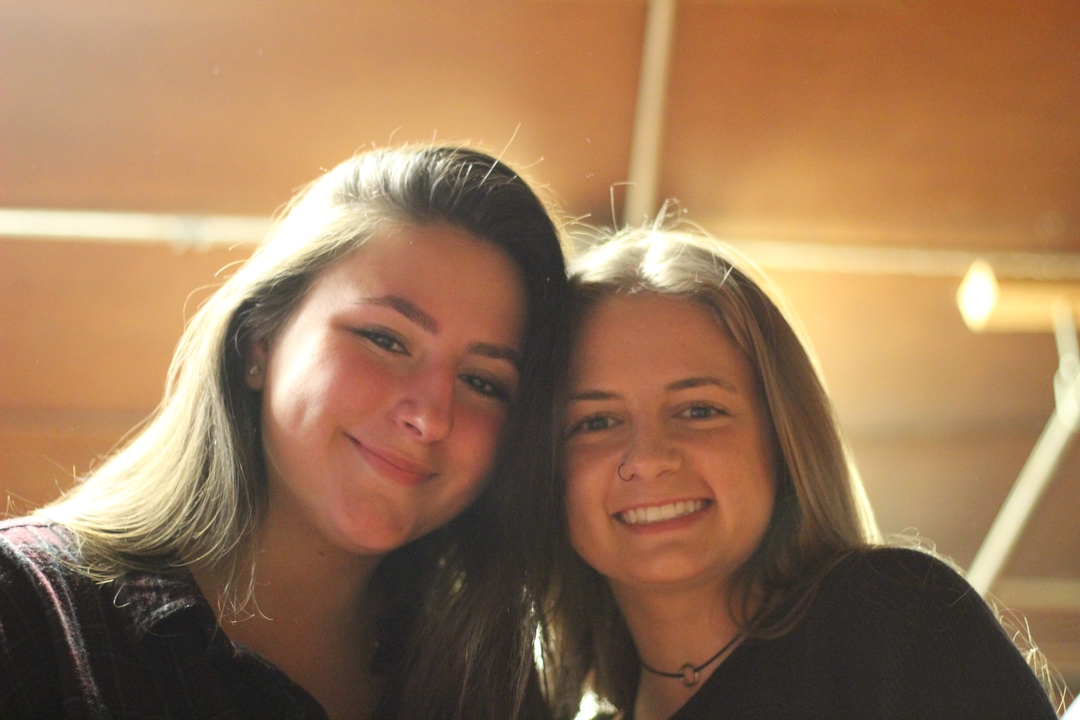 Deux personnes posant à l'intérieur, souriantes.