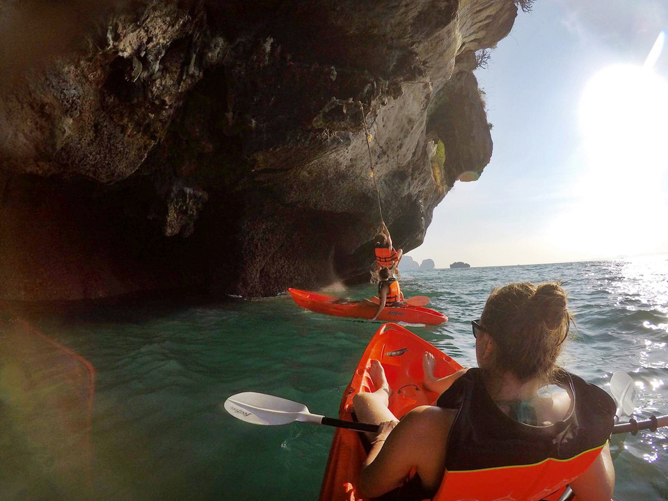Kayakers exploring cliffside waters.