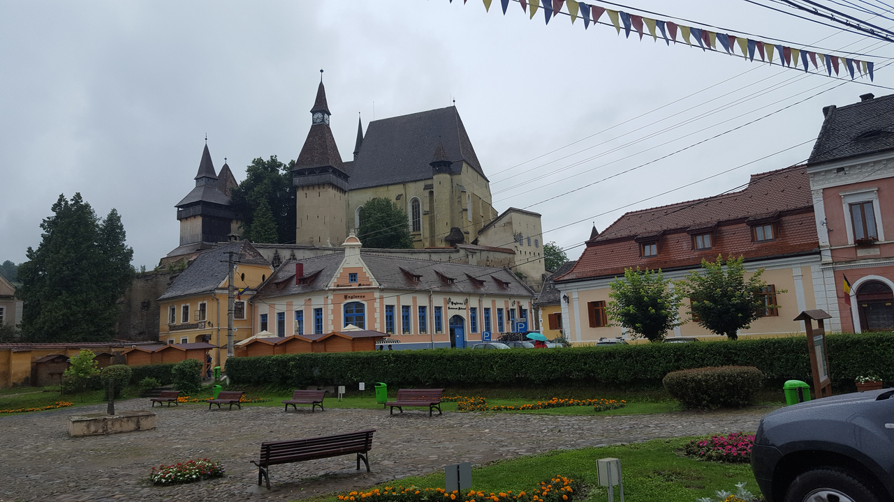 Place de la ville avec des bâtiments historiques et une grande église.