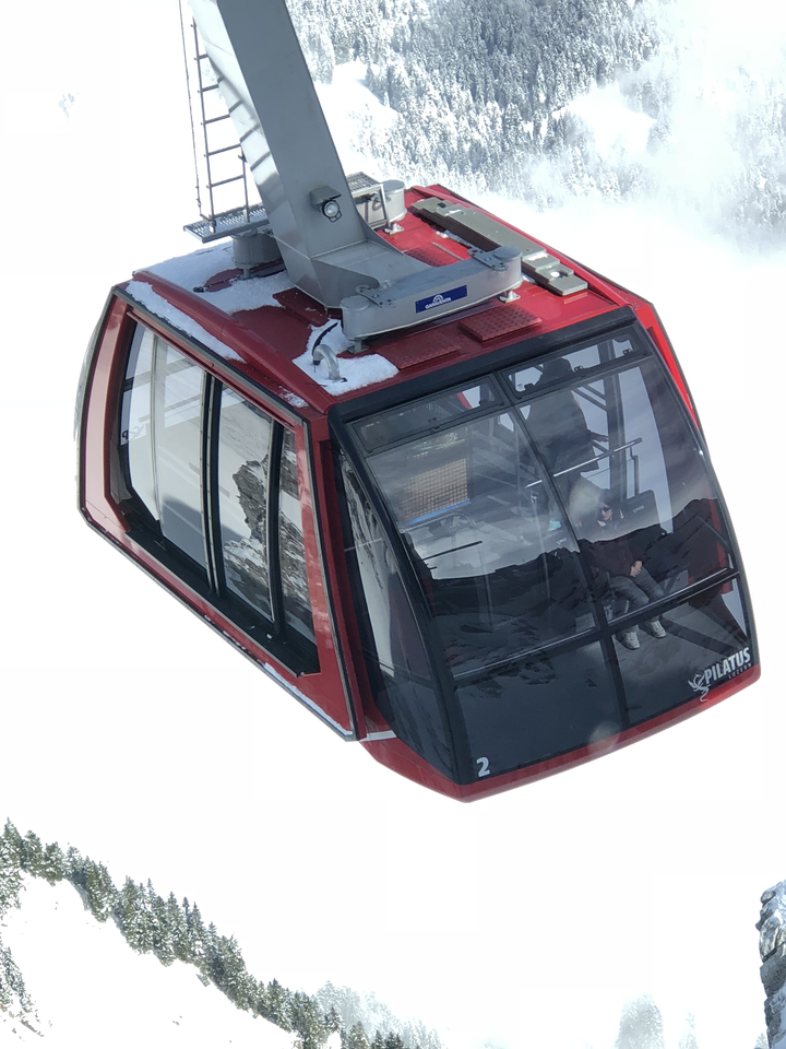 Personne dans un téléphérique avec des montagnes enneigées à l'extérieur