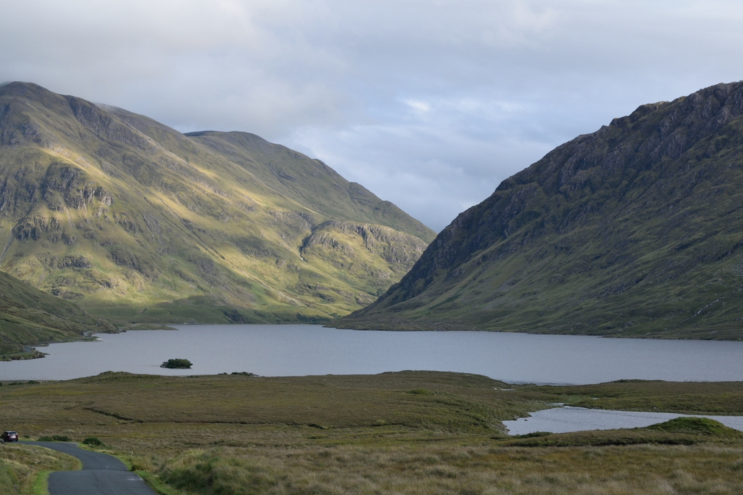 Paysage montagneux avec un lac au premier plan.