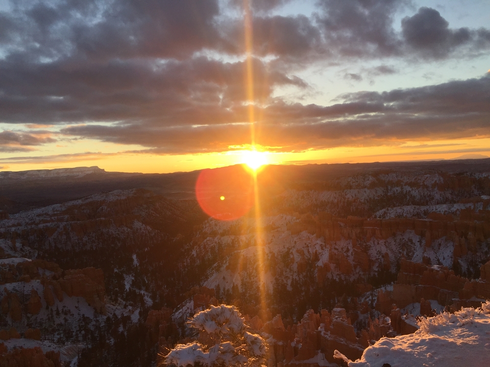 Lever de soleil sur un paysage de canyon enneigé.
