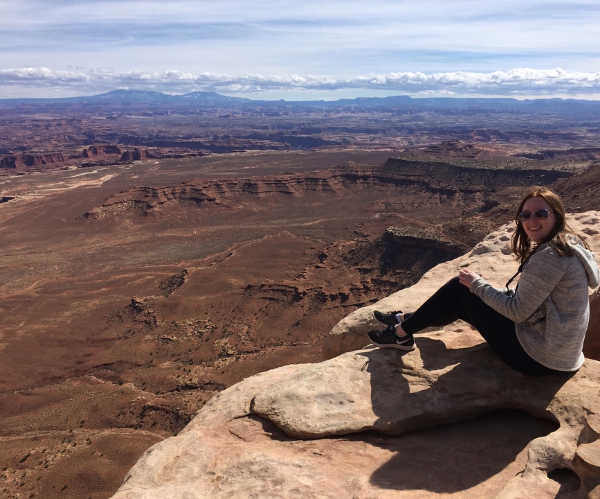 Personne assise au bord d'un canyon.