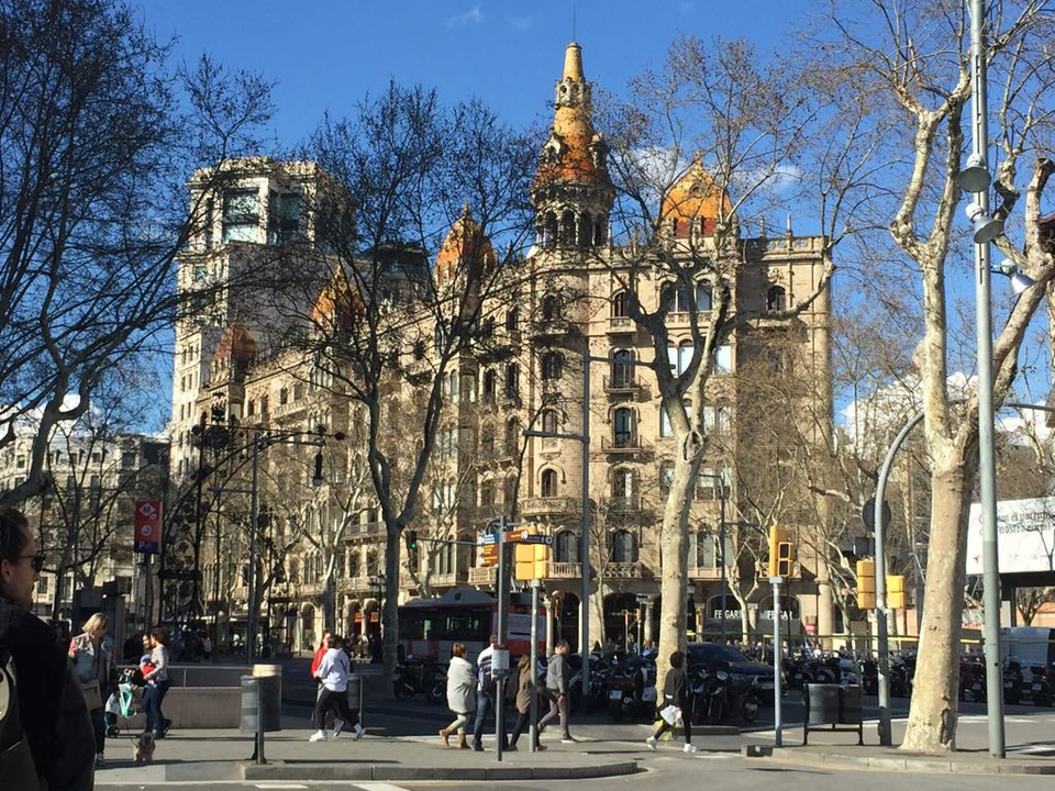 Un bâtiment historique avec une architecture décorative et des gens qui se promènent.