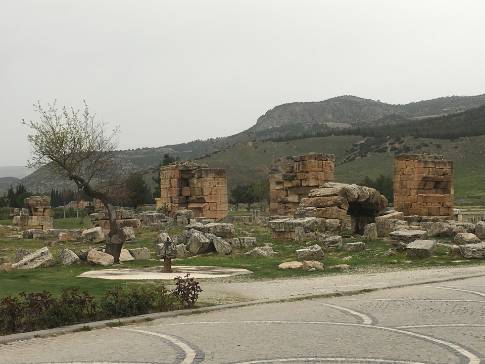 Ruines d'anciennes structures entourées de paysages montagneux.