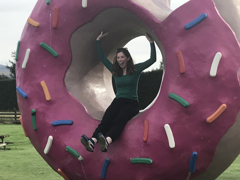 Personne assise à l'intérieur d'une sculpture de donut géant.