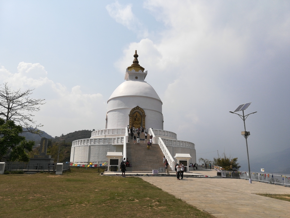 Pagode blanche avec escaliers et visiteurs.
