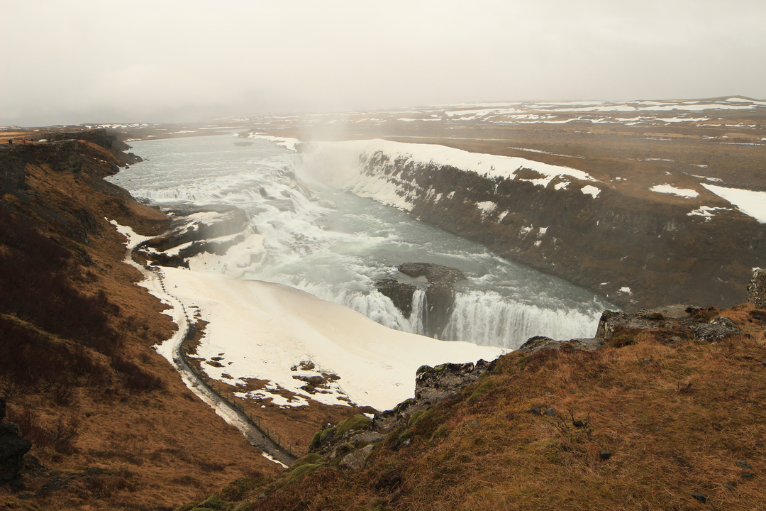 Massive waterfall cutting through frozen landscape.