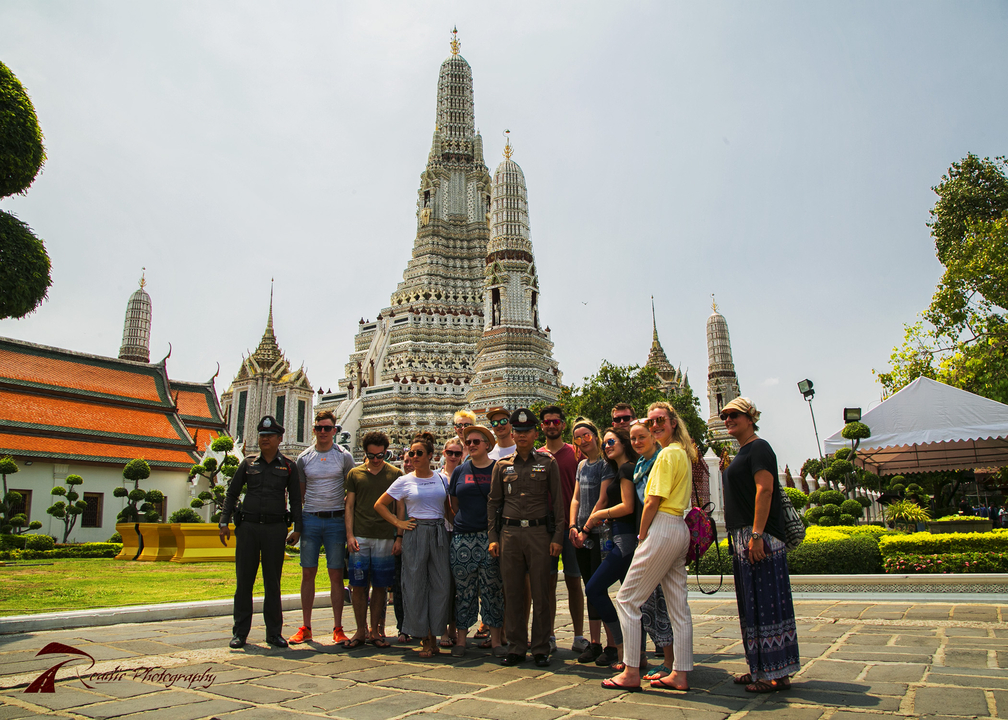 Group posing in front of a temple, possibly in Bangkok.