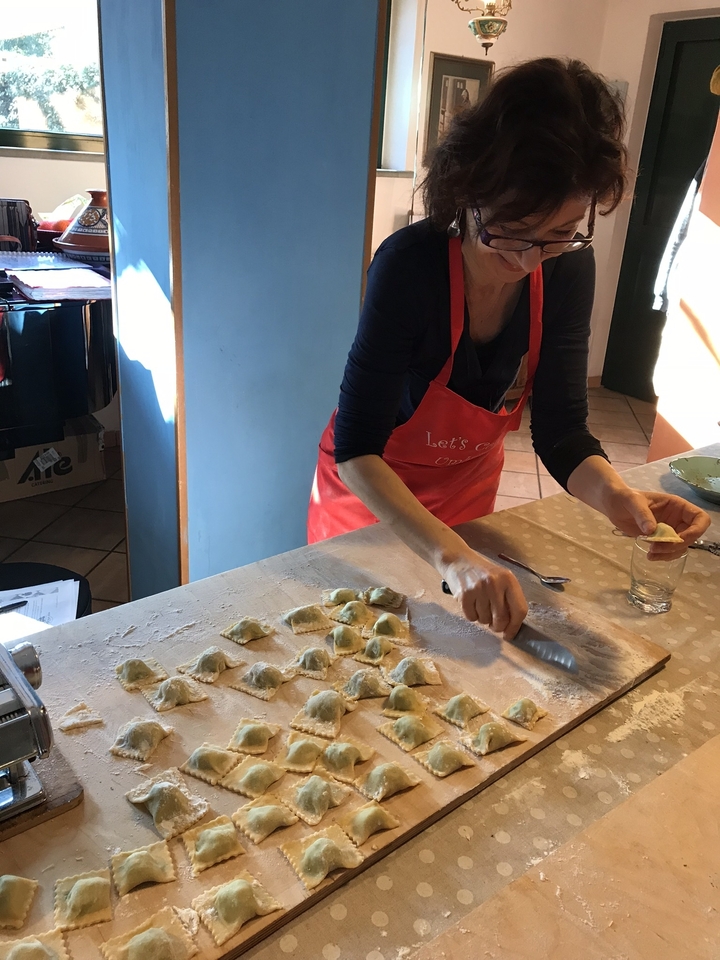 Femme préparant des raviolis avec une fourchette.