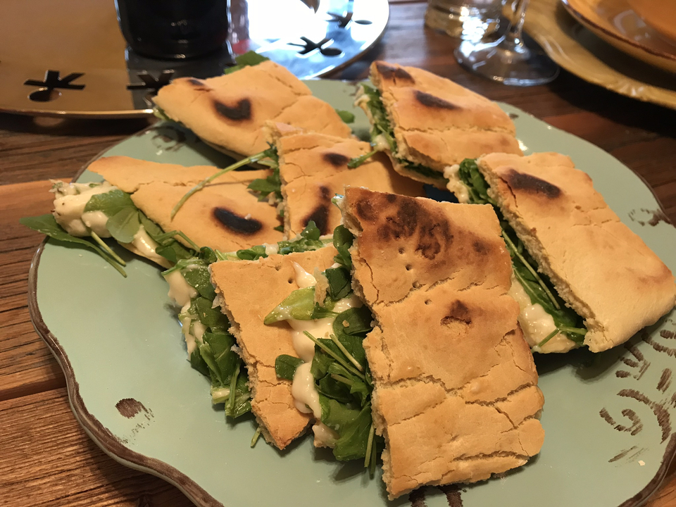 Assiette de bouchées de sandwich avec roquette et fromage.