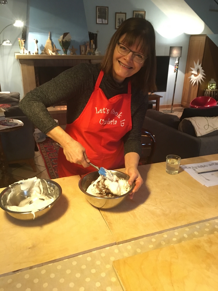 Femme mélangeant des ingrédients dans un bol avec un tablier.