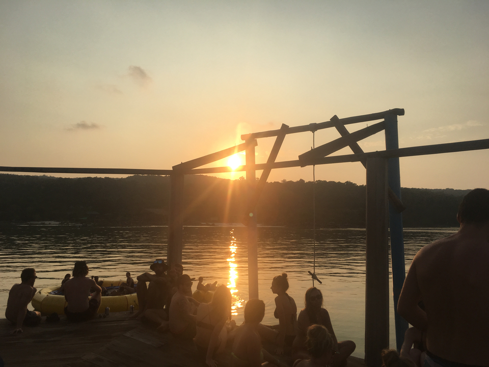 Silhouette of people enjoying a sunset by the water.