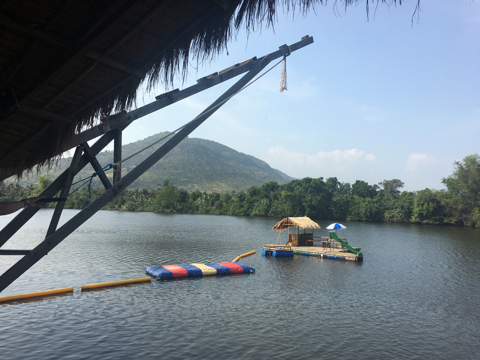 Floating platform on a calm river with mountains in the background.