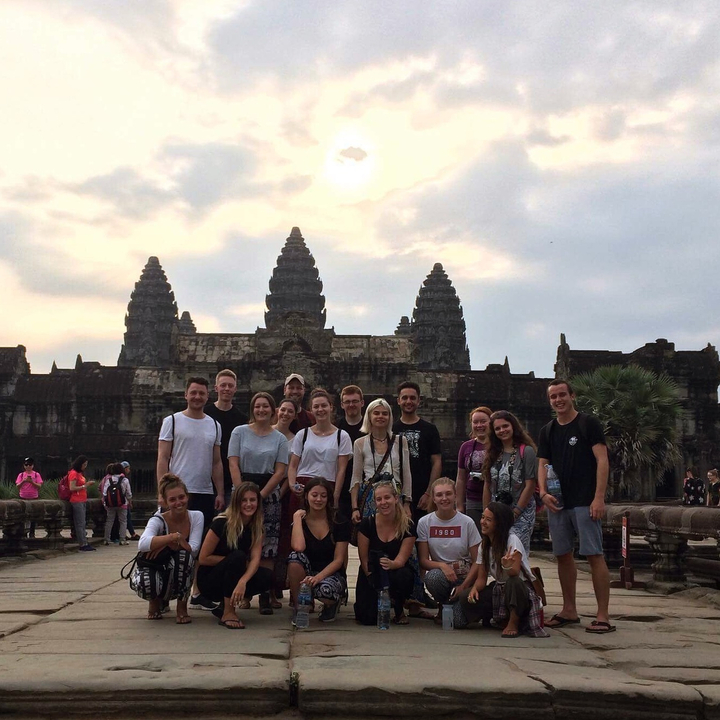 Group on pathway with Angkor Wat temple in the background.