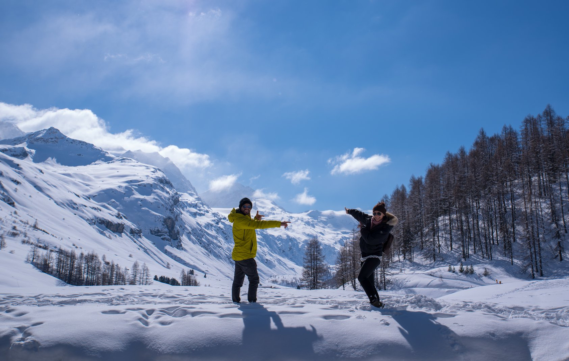 Deux personnes posant dans un paysage de montagne enneigée.