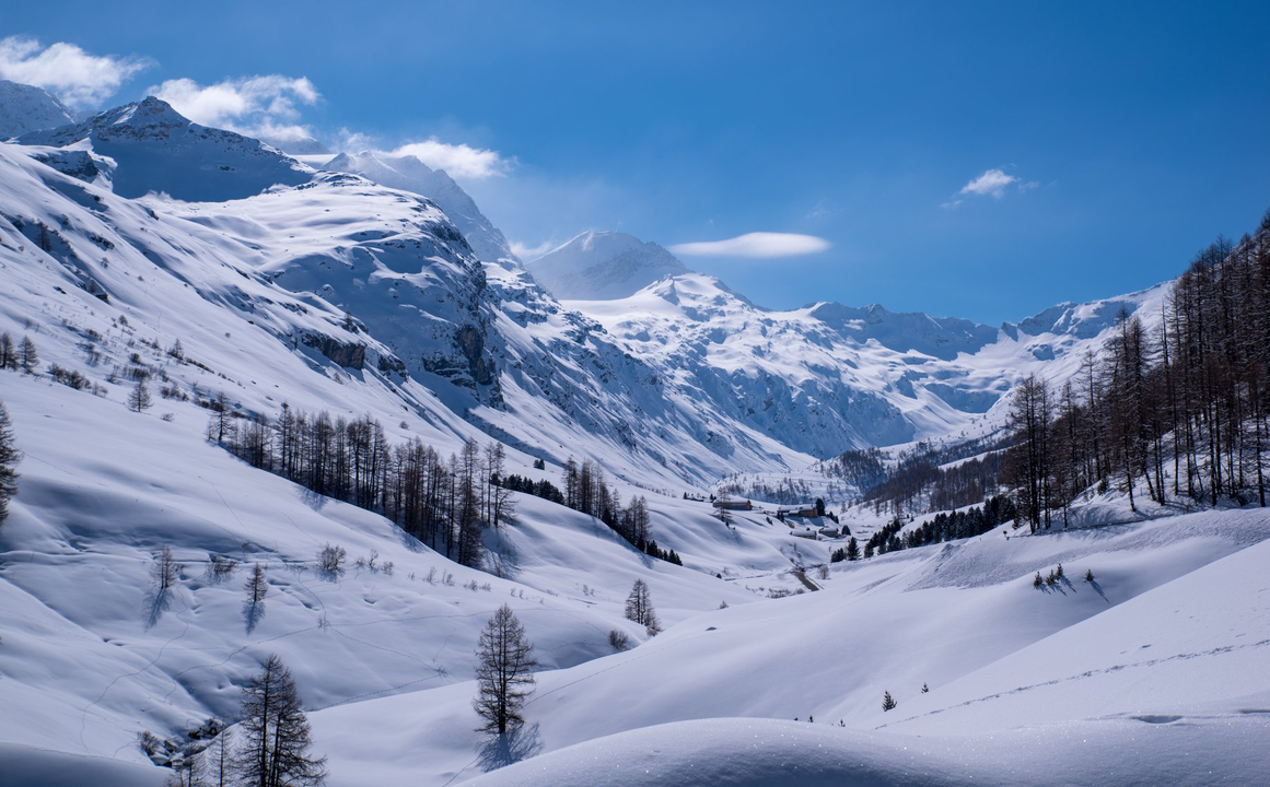 Des montagnes enneigées sous un ciel bleu.