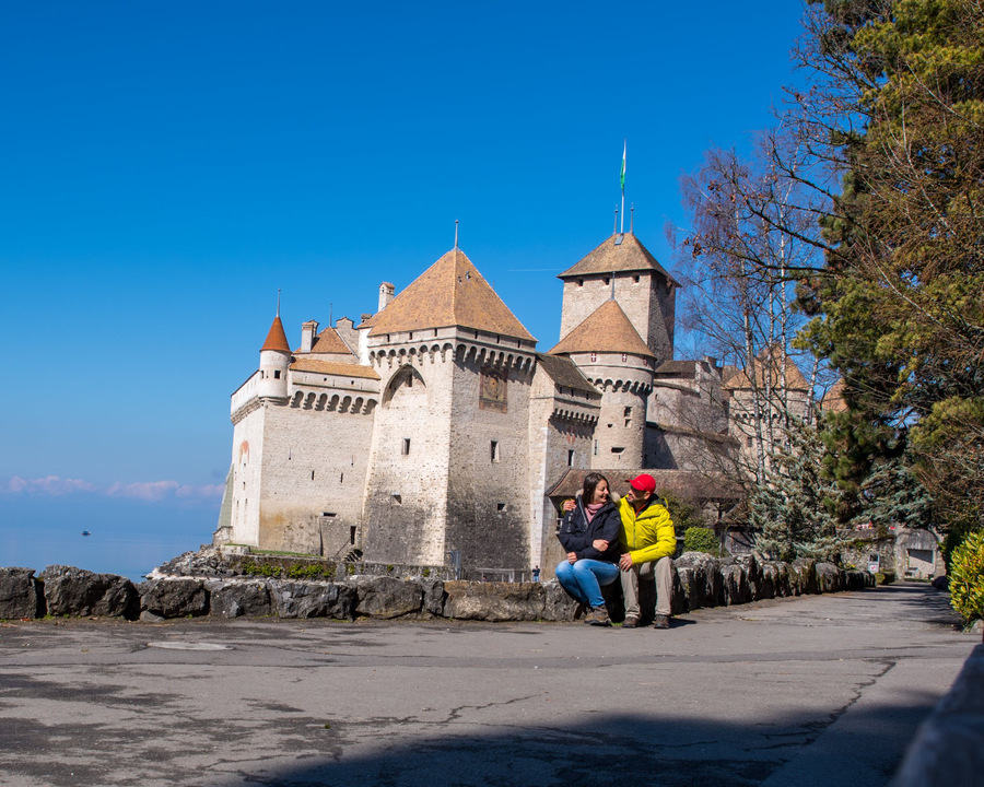 Deux personnes assises devant un château.