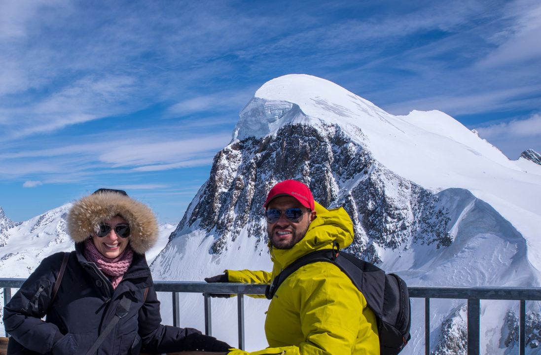 Deux personnes posant devant des montagnes enneigées.