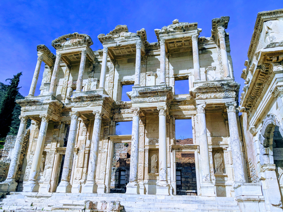 Ruines d'une ancienne bibliothèque avec des colonnes détaillées.