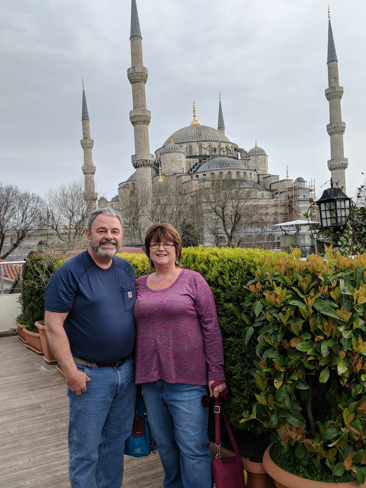 Couple posant devant une mosquée historique.