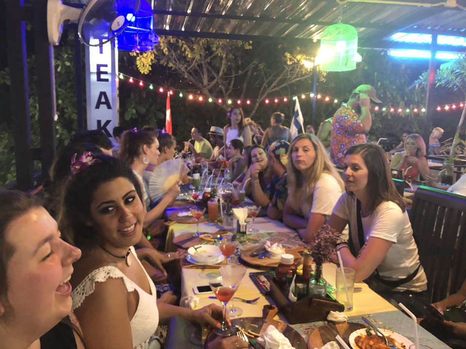 Personnes dînant dans un restaurant avec des places en plein air.