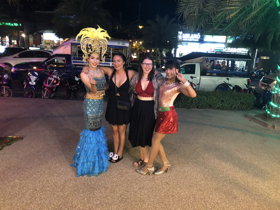 Groupe de personnes posant lors d'un événement nocturne avec des costumes colorés.