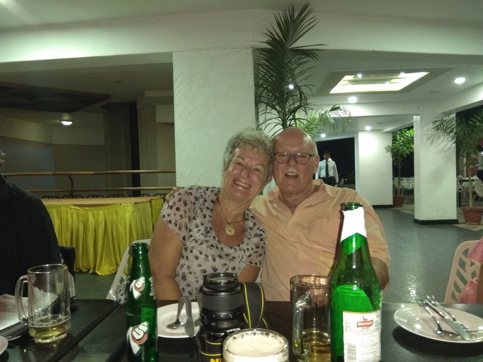 Couple souriant à l'intérieur à une table avec des boissons.