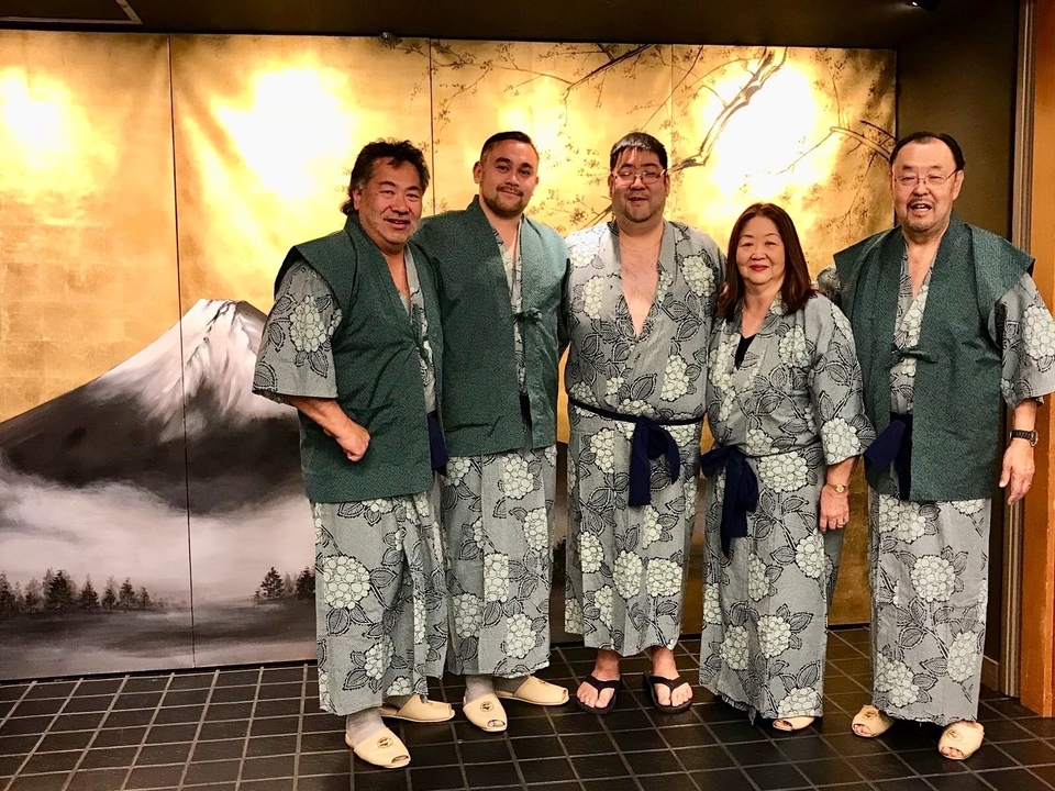 Groupe de personnes portant des yukatas traditionnelles japonaises, posant à l'intérieur.