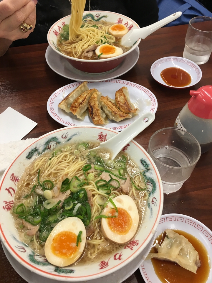 Bol de nouilles ramen avec des gyoza à côté.