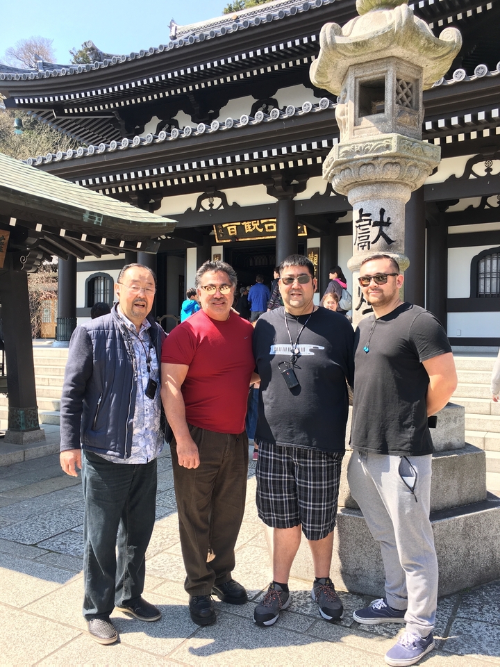 Quatre personnes posant devant un bâtiment traditionnel japonais.
