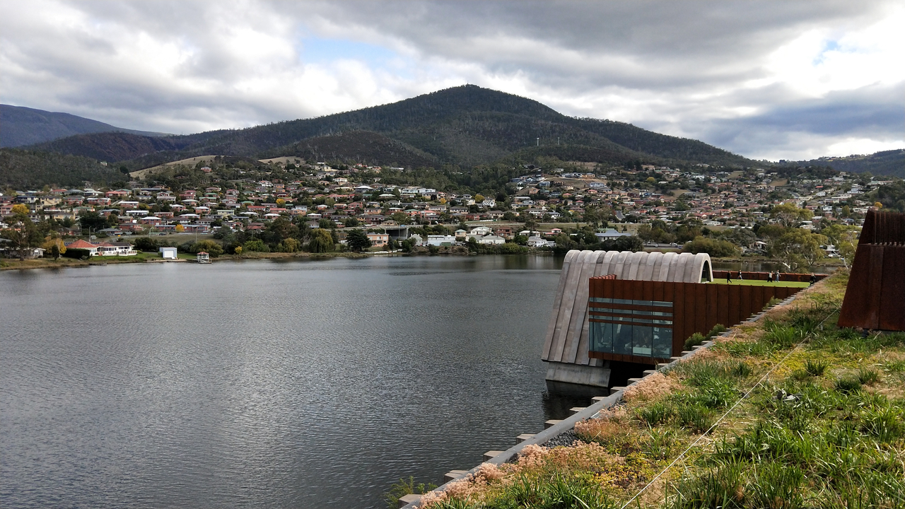 Bâtiment moderne au bord d'un lac avec un arrière-plan vallonné