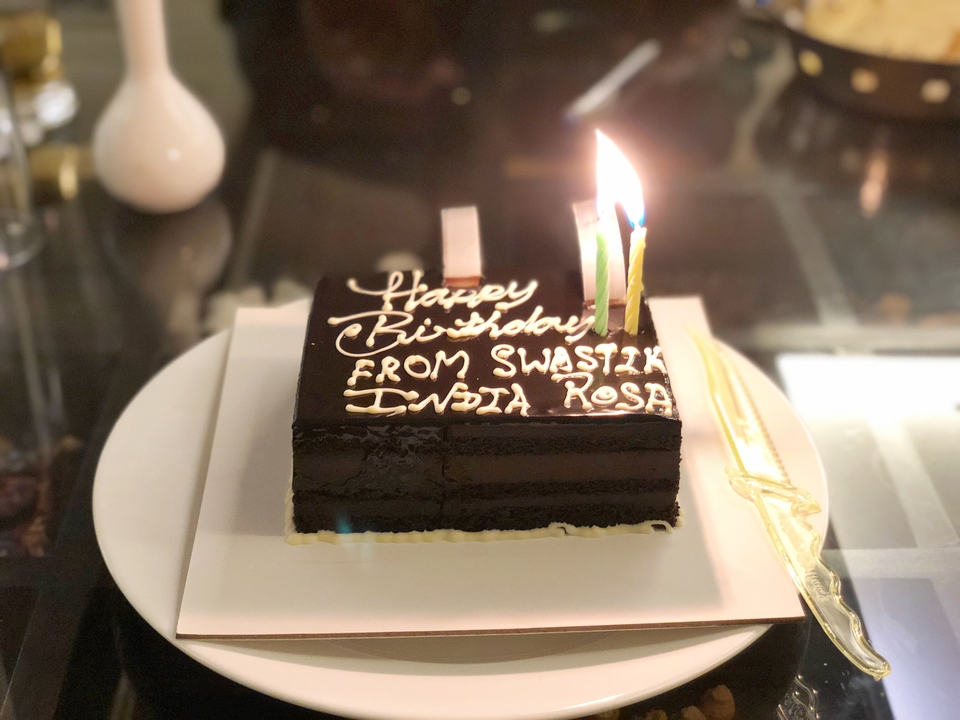 Gâteau d'anniversaire au chocolat avec bougies allumées.