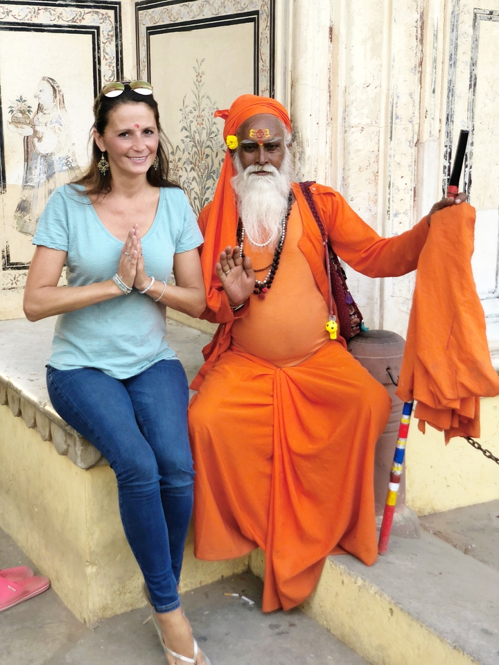 Une femme vêtue d'un haut bleu clair et un homme en robe orange assis l'un à côté de l'autre.