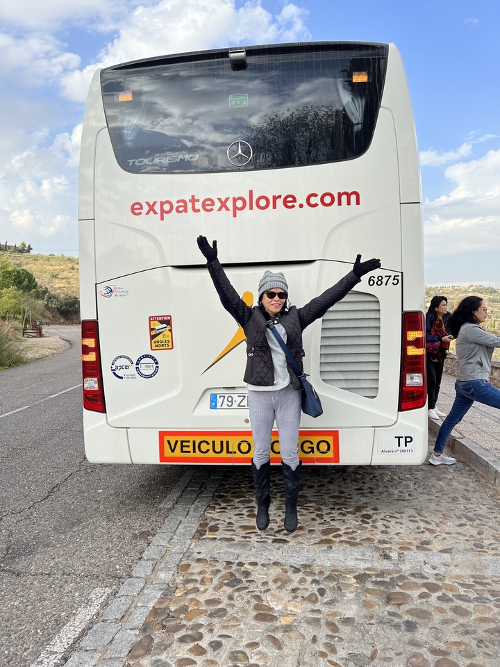 Femme posant devant un autocar de tourisme