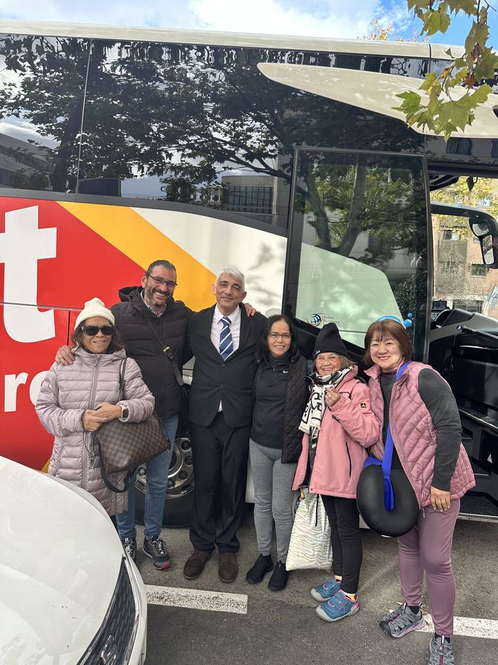 Groupe de personnes posant devant un autocar de tourisme