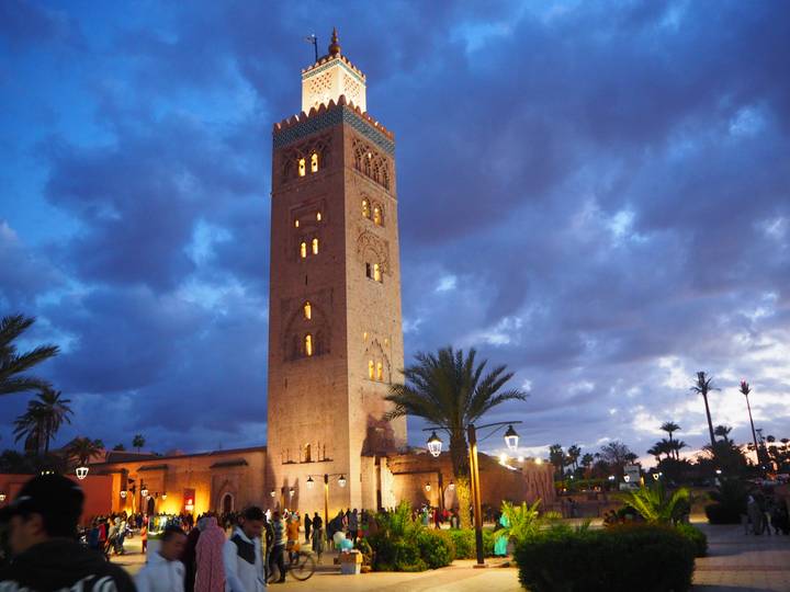Koutoubia Mosque tower under a dramatic cloudy sky.