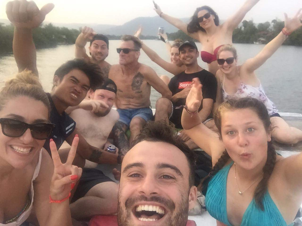 A group of friends posing excitedly on a boat.