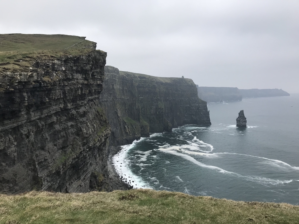 Les falaises de Moher par temps nuageux, les vagues s'écrasant en contrebas.