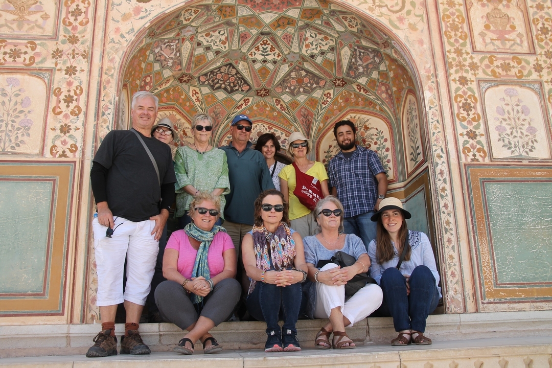 Eine Gruppe von Touristen posiert vor einer bunten Architektur.