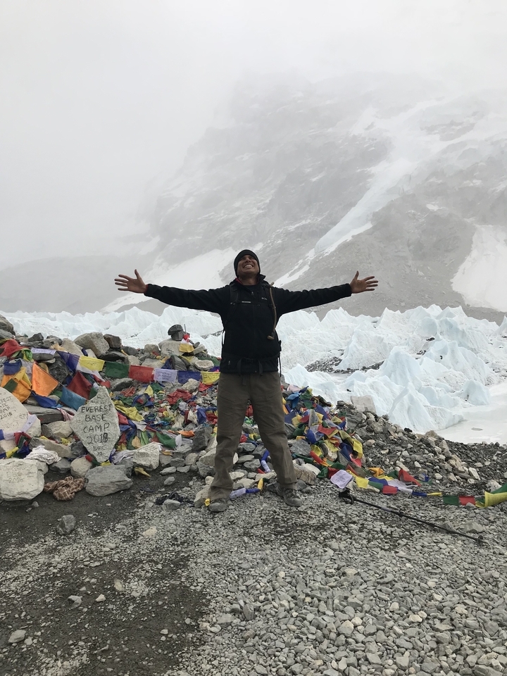 Une personne s'étirant joyeusement les bras au camp de base de l'Everest.
