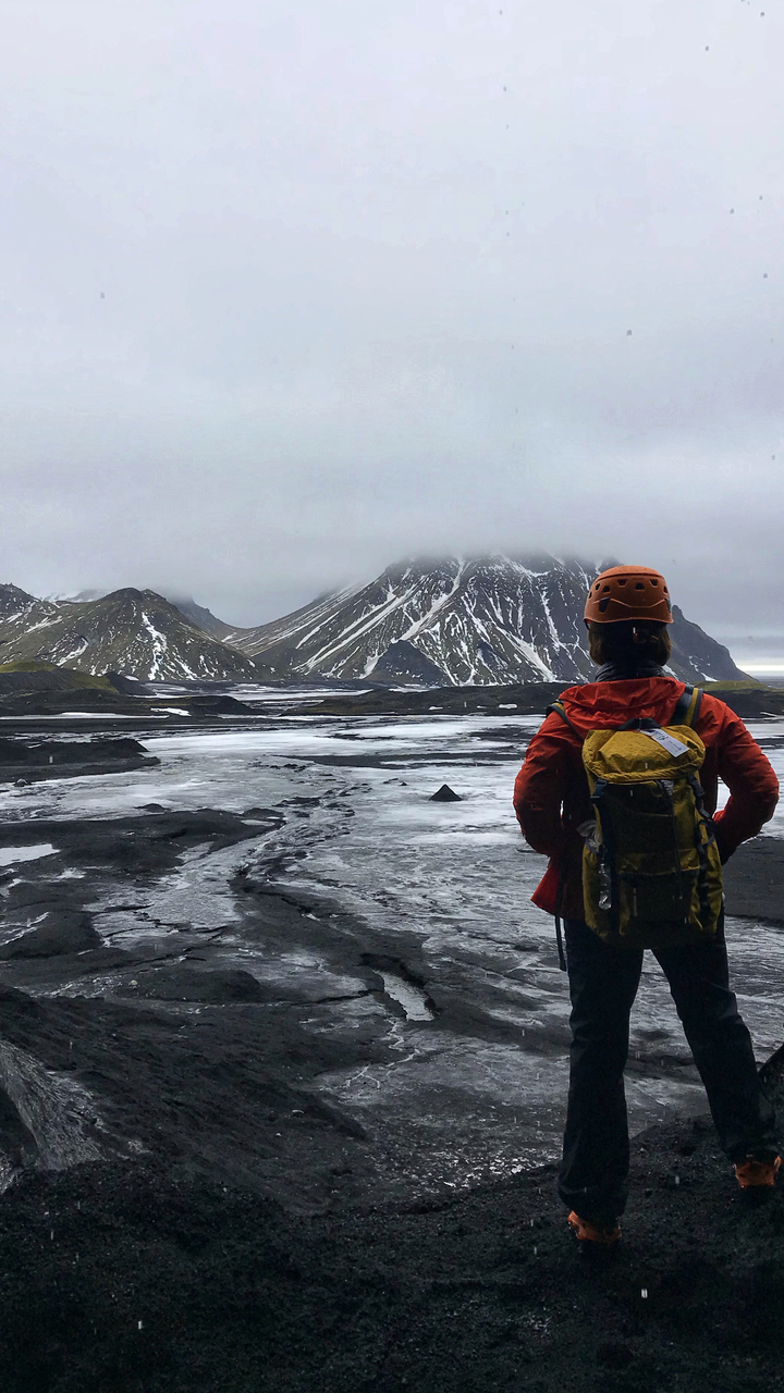 Person overlooking snow-covered volcanic landscape.