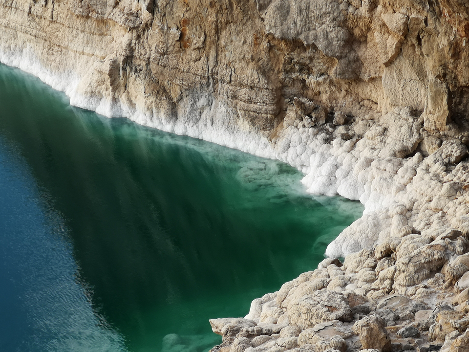 Close-up of salt formations and clear water.