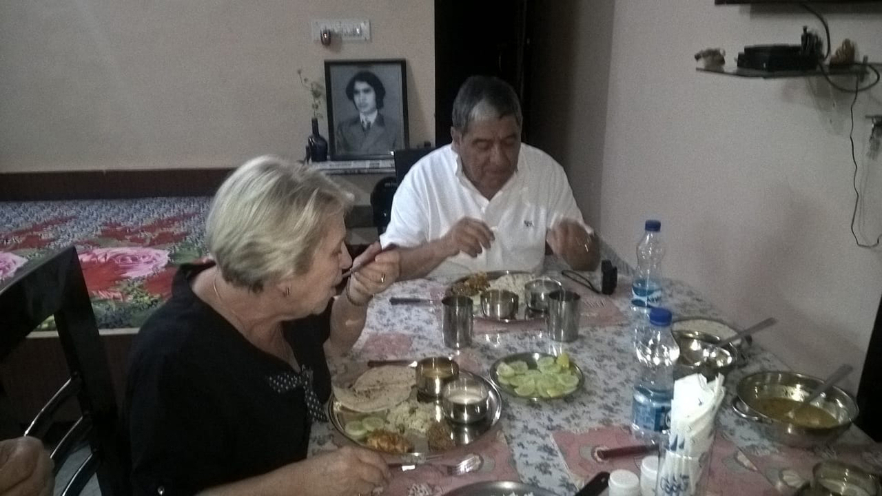 Deux personnes mangeant à une table à l'intérieur.
